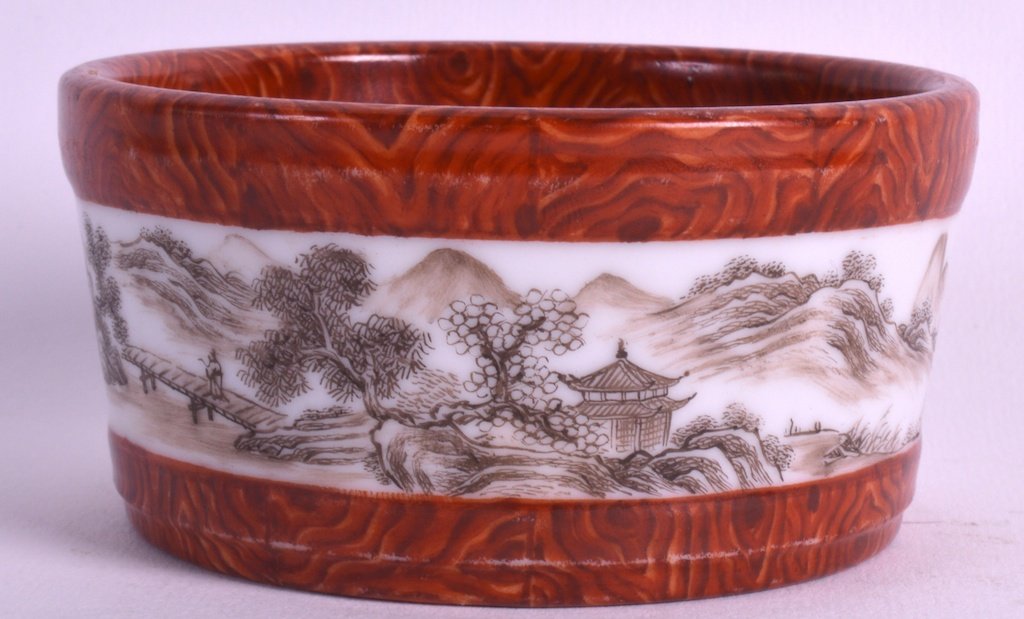 AN EARLY 20TH CENTURY CHINESE IMITATION AGATE CIRCULAR: AN EARLY 20TH CENTURY CHINESE IMITATION AGATE CIRCULAR PORCELAIN BRUSH WASHER bearing Yongzheng marks to base, painted in sepita with landscapes. 3.25ins diameter.