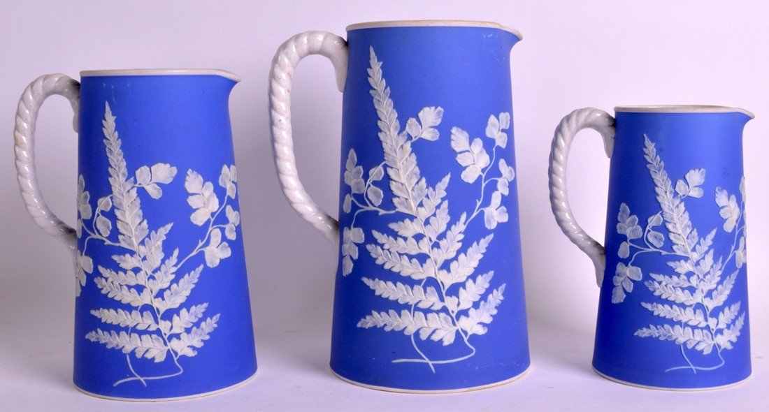 A SET OF THREE 19TH CENTURY PAXTON JASPERWARE GRADUATED: A SET OF THREE 19TH CENTURY PAXTON JASPERWARE GRADUATED JUGS decorated with floral studies. Largest 8.25ins high.