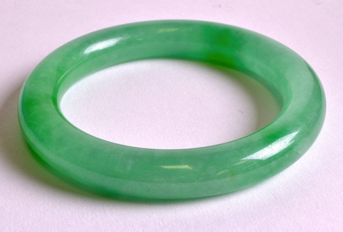 A CHINESE GREEN JADEITE CIRCULAR BANGLE 20th Century. (1 of 1)