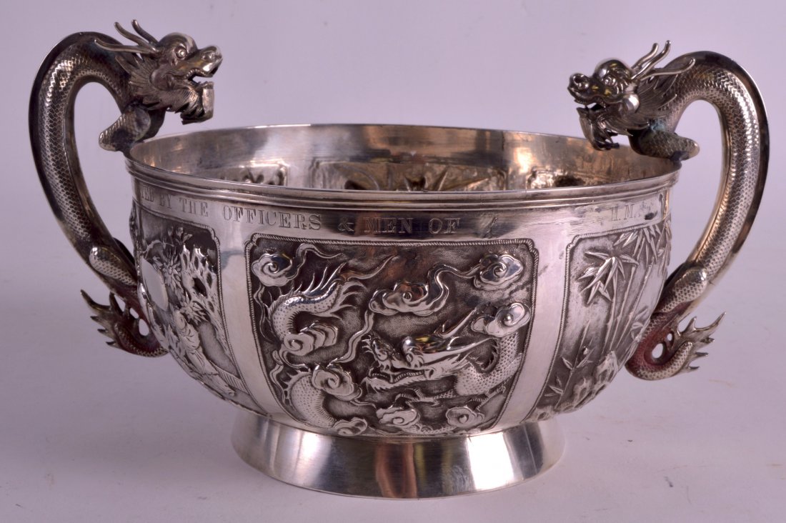 A LATE 19TH CENTURY CHINESE TWIN HANDLED SILVER BOWL by: A LATE 19TH CENTURY CHINESE TWIN HANDLED SILVER BOWL by Wang Hing, decorated in relief with panels of flowering rock and vines. 466 grams. 8.5ins diameter.