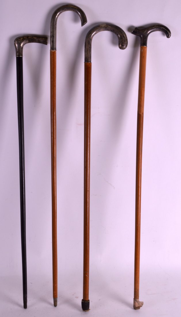 A SET OF FOUR SILVER TOPPED WALKING CANES with ebony: A SET OF FOUR SILVER TOPPED WALKING CANES with ebony and Malacca shafts. Longest 3ft 1ins. (4)