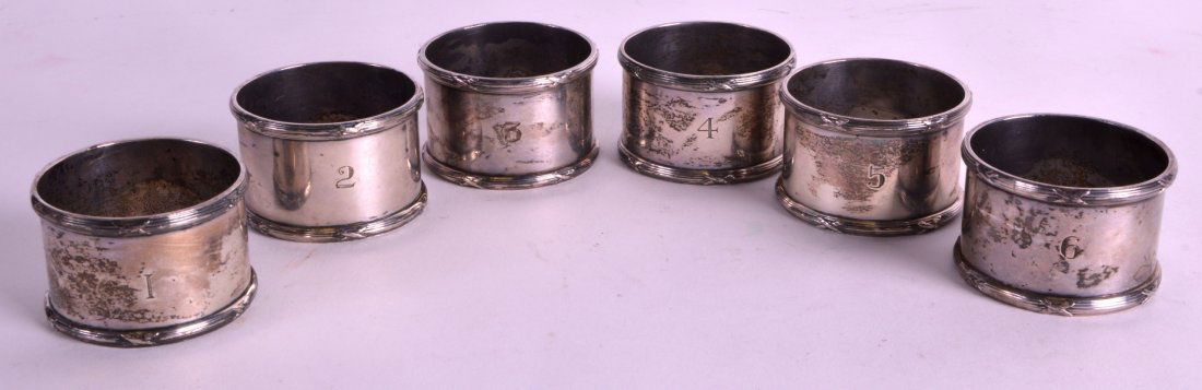 A SET OF SIX HEAVY SILVER NAPKIN RINGS each with an (1 of 1)