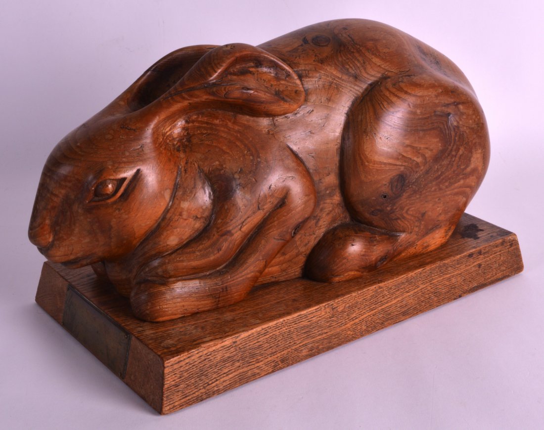 A 1940S SCOTTISH CARVED WOOD MODEL OF A HARE presented: A 1940S SCOTTISH CARVED WOOD MODEL OF A HARE presented to John Crawford, by the Stewartry of Kirkcudbright. 12.5ins wide.