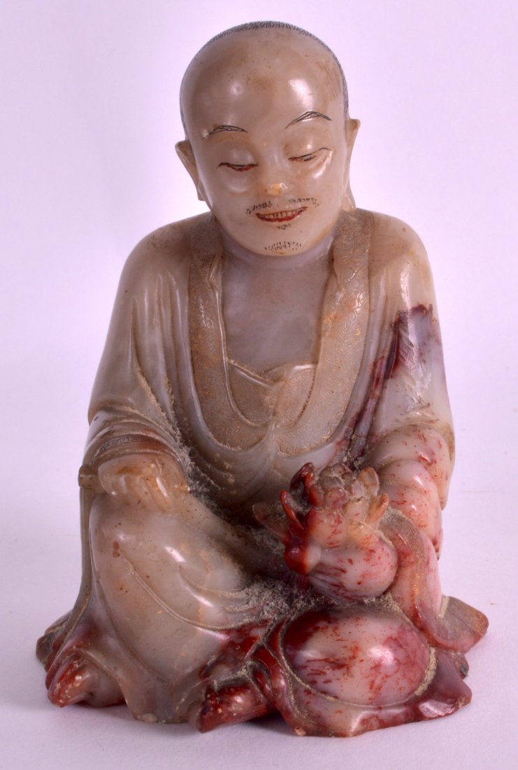 A FINE 17TH/18TH CENTURY CHINESE CARVED SOAPSTONE: A FINE 17TH/18TH CENTURY CHINESE CARVED SOAPSTONE FIGURE OF A BUDDHA Kangxi/Yongzheng, modelled holding a floral sprig. 3.75ins high.