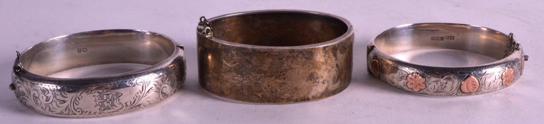 A GROUP OF THREE EDWARDIAN ENGRAVED SILVER BANGLES. (3): A GROUP OF THREE EDWARDIAN ENGRAVED SILVER BANGLES. (3)