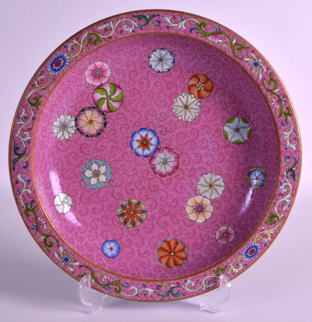 A CHINESE FAMILLE ROSE PORCELAIN CIRCULAR DISH 20th: A CHINESE FAMILLE ROSE PORCELAIN CIRCULAR DISH 20th Century, bearing Qianlong marks to base, painted with floral roundels upon a scrolling pink ground. 10.75ins diameter.