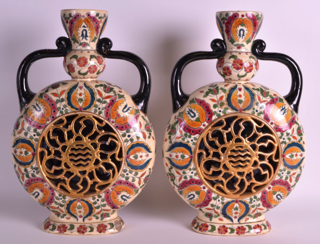 A PAIR OF LATE 19TH CENTURY HUNGARIAN FISCHER ZSOLNAY: A PAIR OF LATE 19TH CENTURY HUNGARIAN FISCHER ZSOLNAY TWIN HANDLED VASES with reticulated bodies, painted with flowers and vines. 14.5ins high.