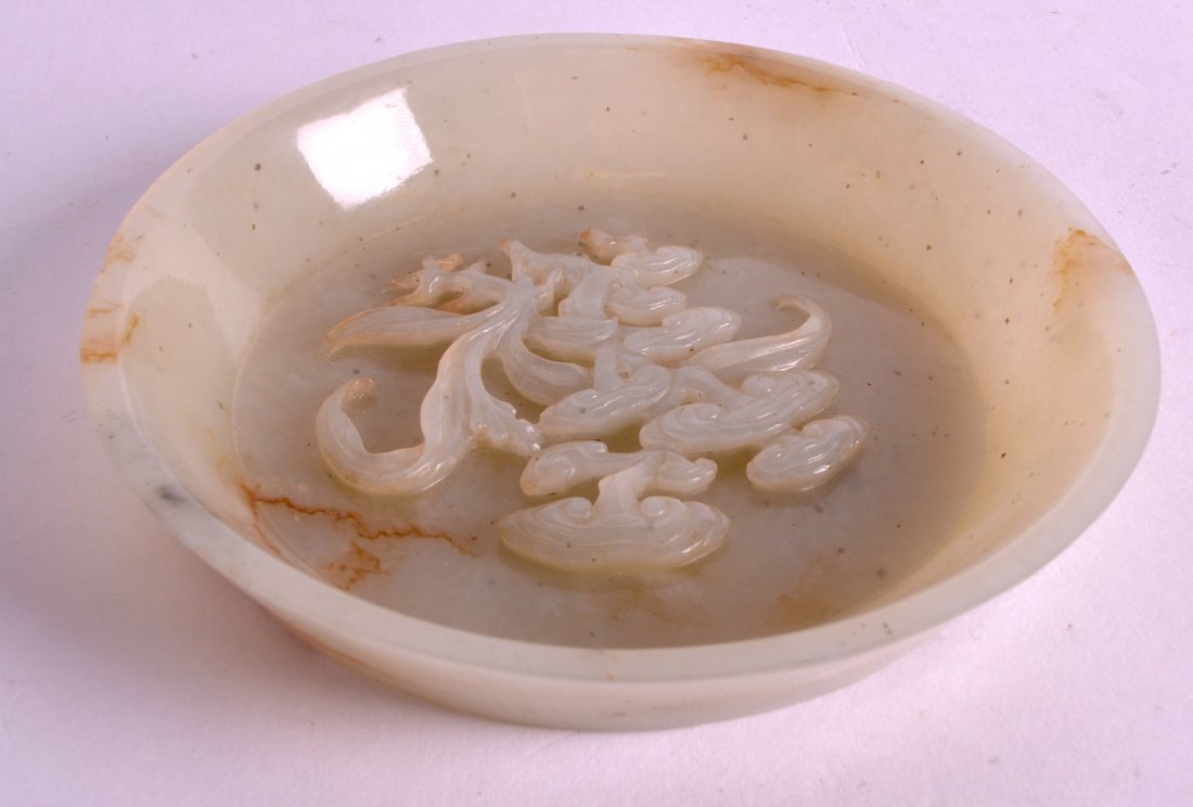 A CHINESE QING DYNASTY GREEN JADE BRUSH WASHER: A CHINESE QING DYNASTY GREEN JADE BRUSH WASHER decorated with a organic lingzhi fungus. 4.5ins diameter.