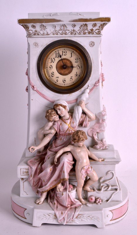 A LATE 19TH CENTURY GERMAN PORCELAIN MANTEL CLOCK: A LATE 19TH CENTURY GERMAN PORCELAIN MANTEL CLOCK modelled as a classical female with two children, the dial decorated with black numerals. 1Ft 2.5ins high.