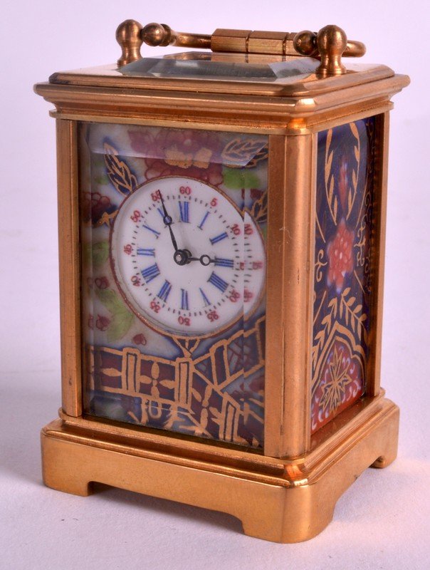 A MINIATURE FRENCH ORMOLU CARRIAGE CLOCK inset with: A MINIATURE FRENCH ORMOLU CARRIAGE CLOCK inset with imari porcelain panels of flowers. 2.75ins high inc handle.