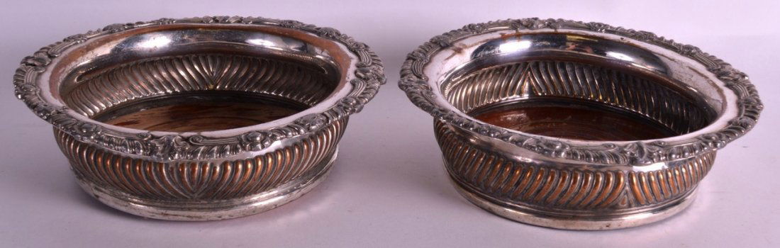 A PAIR OF 19TH CENTURY OLD SHEFFIELD PLATE WINE: A PAIR OF 19TH CENTURY OLD SHEFFIELD PLATE WINE COASTERS with floral borders. 7Ins diameter.