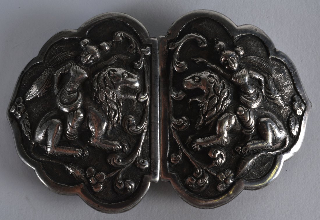 A 19TH CENTURY BURMESE SILVER BUDDHISTIC BUCKLE: A 19TH CENTURY BURMESE SILVER BUDDHISTIC BUCKLE decorated with figures upon beasts. 3.75ins wide.