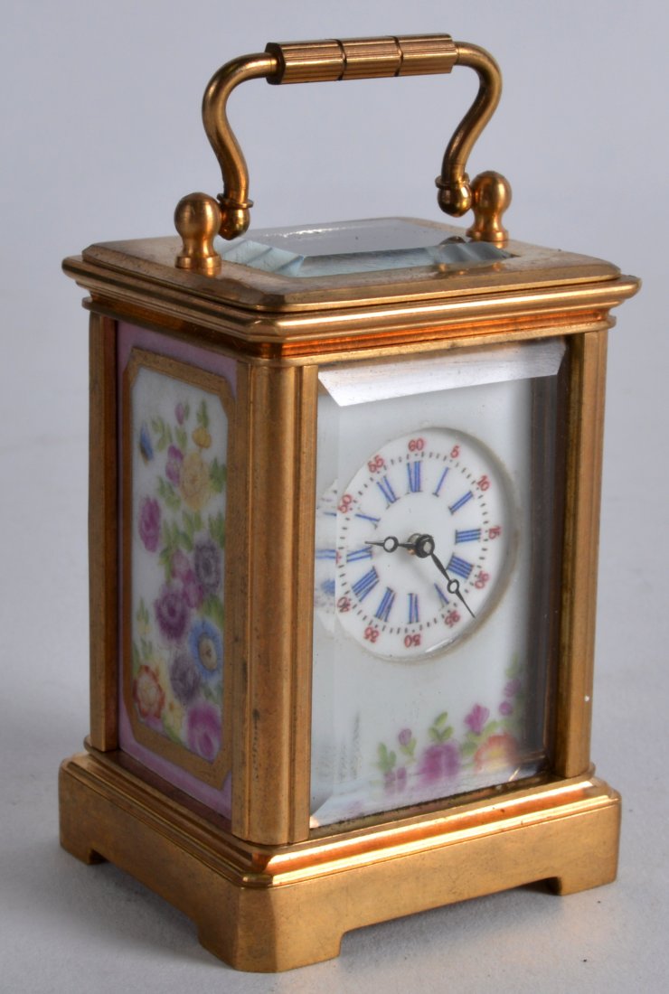 A MINIATURE BRASS CARRIAGE CLOCK inset with painted (1 of 3)
