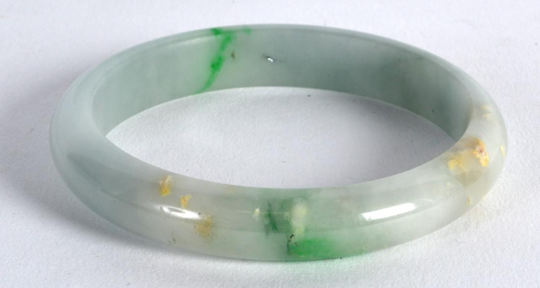 A CHINESE CARVED GREEN JADEITE CIRCULAR BANGLE. 3Ins (1 of 2)