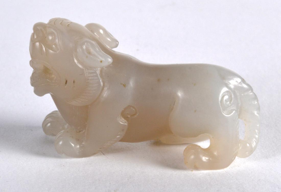 A CHINESE CARVED WHITE JADE FIGURE OF A BEAST modelled (1 of 2)