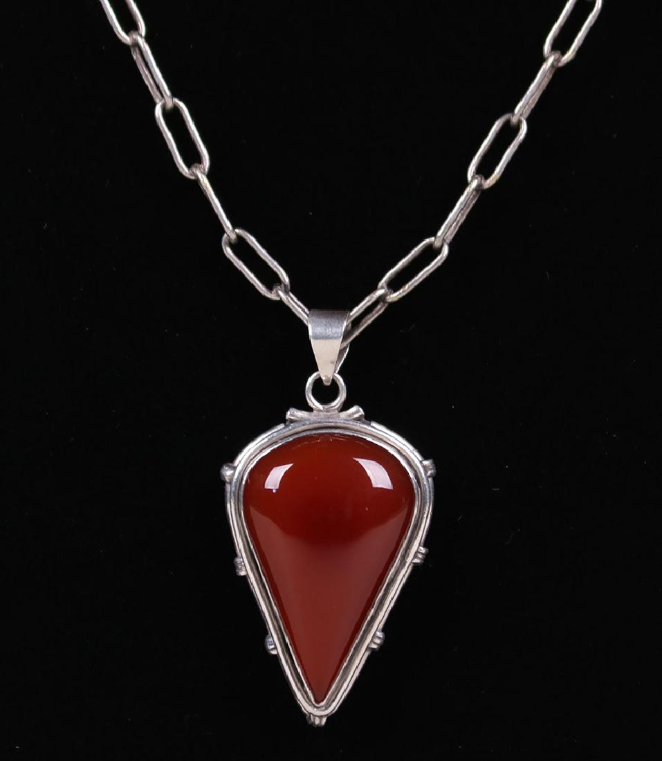 Arts & Crafts Sterling Silver Carnelian Pendant: Arts & Crafts sterling silver pendant with inset carnelian and hand made paper clip silver chain c1910. Unsigned. 15" length. Pendant 2"h x 1"w. Spend $5000 or more at this auction and all of your SHI