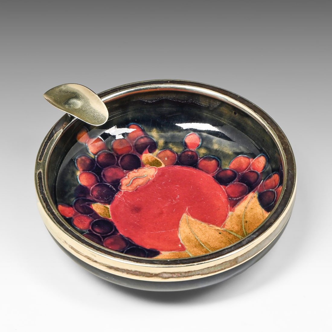 Moorcroft Burslem Pomegranate Ashtray Sterling Silver Mount c1914: Moorcroft Burslem Pomegranate Ashtray Sterling Silver Mount c1914. Signed. Small chip to base rim, otherwise perfect condition. 5.5"d x 1.75"h FREE NATIONWIDE SHIPPING Free Nationwide Shipping within