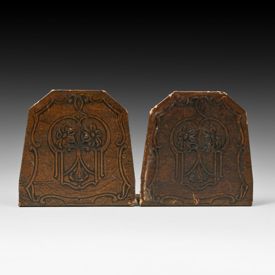 Arts & Crafts Modeled Leather Floral Bookends c1910: Arts & Crafts Modeled Leather Floral Bookends c1910. Unsigned. Very good condition with a dark, uncleaned original finish. Displays honest edge wear and light surface loss to backings consistent with