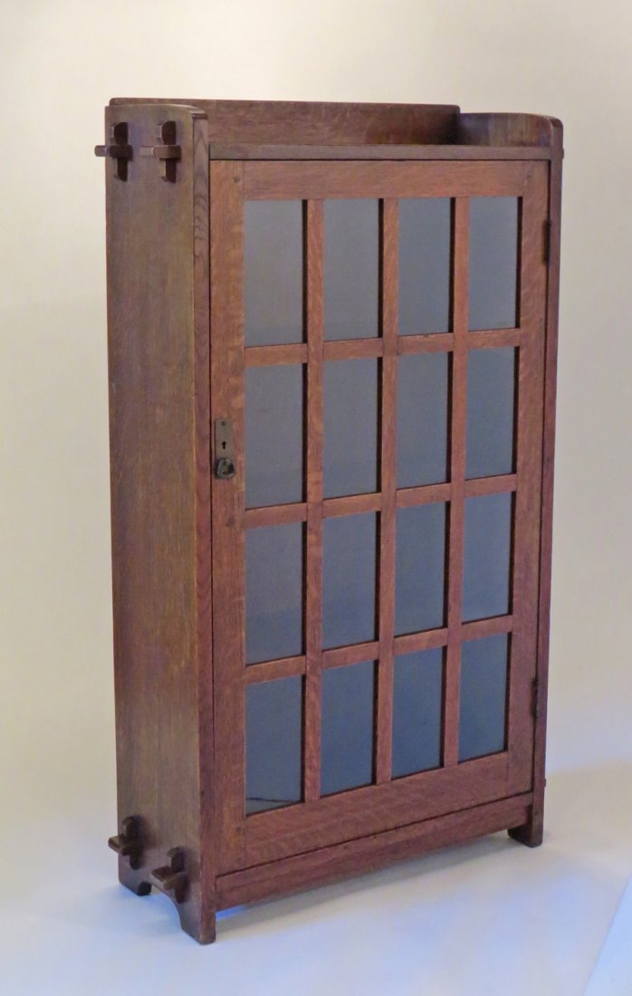L&JG Stickley One-Door Bookcase: L&JG Stickley narrow one-door bookcase with tenon & key construction. Signed with branded mark on inside of door "The Work of L&JG Stickley". 55"h x 33.5"w x 12"d.Larger piece are shipped via Steve Au