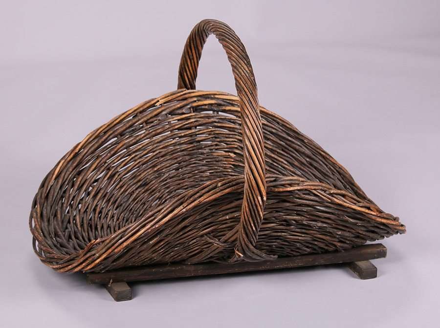 Gustav Stickley Firewood Log Basket: Gustav Stickley willow one-handled fire wood log basket. Pictured on page 58 of Craftsman Furnishings for the Home October 1912. Unsigned. 18"h x 21"d x 26"w. We box and ship ourselves, to keep shippi