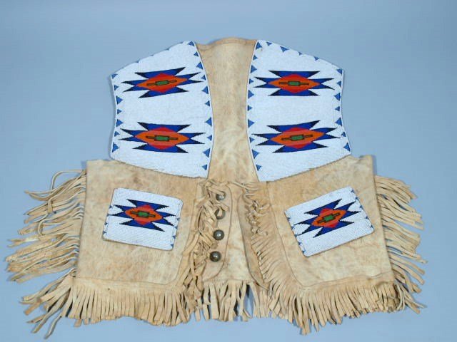 Northern Plains Beaded Vest: Native American Northern Plains beaded vest. Trade beads well sewn on tanned hide, buttons are made from buffalo nickels. Beaded on one side, early trade cloth inside arm holes. 21 inches tall and 20 