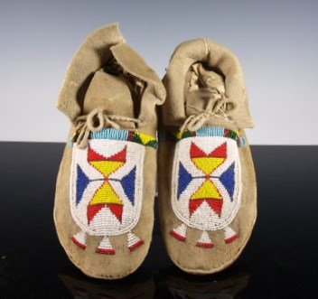 Crow Beaded Moccasins, Shows Use: Crow Native American beaded moccasins showing wear to soles. Light blue buffalo track pattern. 9.5 inches long
