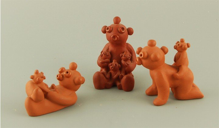 Mud head pottery storytellers: Native American Three unsigned clay Mud head clown storytellers. Lying Mud head 3" long, sitting Mud head storyteller with three babies, 3" h, Mud head with baby on back, 3" long.