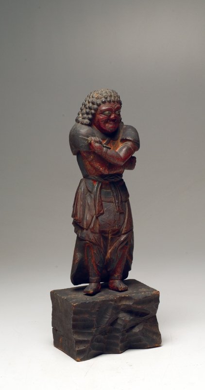 Japanese Edo Wood Figure of Nio: Edo period, ca. 17th century. Size: 12-3/4â€H. Carved hardwood standing figure Nio, clutching his chest with both arms, holding a double headed thunderbolt weapon in his left hand. Expressive facia