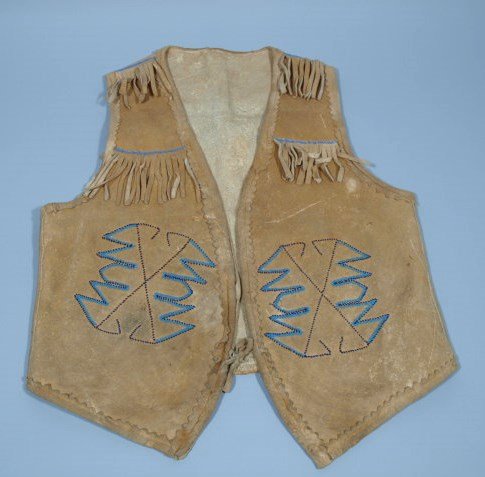 Northern Plains Beaded Vest: Native American Northern plains beaded vest, with trade beads and fringe. One line of blue beads crossing the back. Made from soft tanned hide. 22inches tall and 18 inches wide not including fringe.