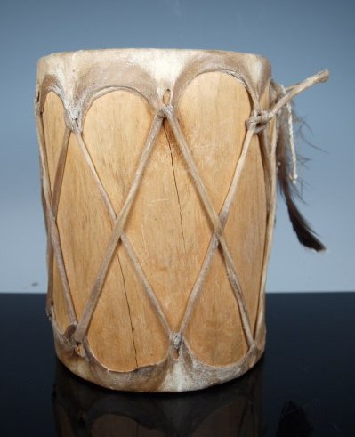 Small Pueblo Drum, Cottonwood: Unpainted Cottonwood Pueblo drum. Sweet. Rawhide heads & laces, turkey feather suspension. Dimensions: 6.75 in. high x 5.25 in. diameter