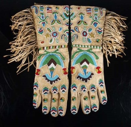 Fringed & Beaded Hide Gauntlets, American Flags: Fringed and ornately beaded pictorial hide gauntlets (Santee Sioux?) with floral devices, stars, and American Flags. Beadwork shows on cuffs, just above the seam between cuffs and gloves, and the tops