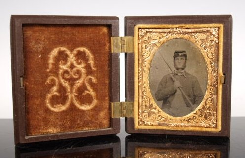 Civil War photograph Confederate soldier with rifle: In original small carring frame showing a Civil War soldier with weapon in hand. 3" x 2 3/4" Civil War Plate Gutta-Percha Case Containing an tintype photograph of a Civil War soldier with weapon in ha