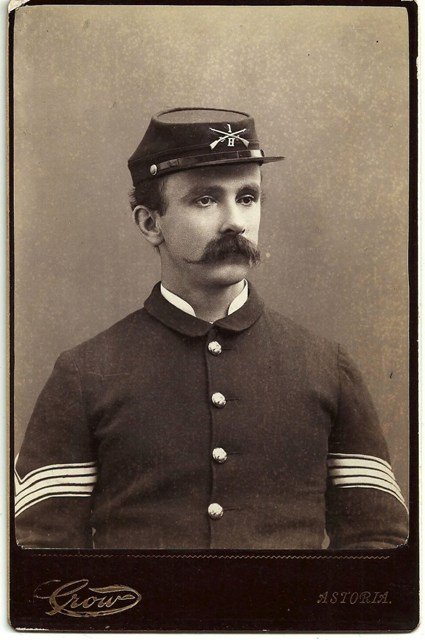ASTORIA, OREGON INFANTRY SERGEANT WITH UNIT BADGE – ca.: "ASTORIA, OREGON INFANTRY SERGEANT WITH UNIT BADGE – ca. 1884-91. Nice maroon and gold-rimmed cabinet card by Samuel B. Crow, who is noted for operating his studio throughout Oregon for 40 years, 18