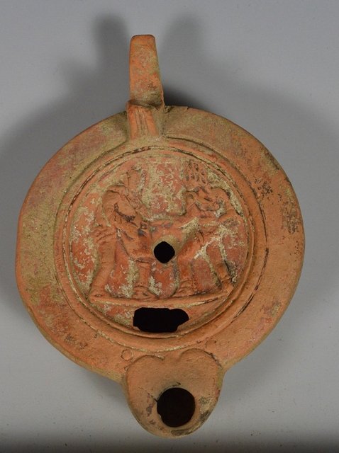 Ancient Roman Oil Lamp - Gladiators in battle: Rome, ca. 1st century CE. a very detailed Terracotta oil lamps showing an armor clad gladiators engaged in battle with another man who wears no armor and appears to being run through with a spear. Mak