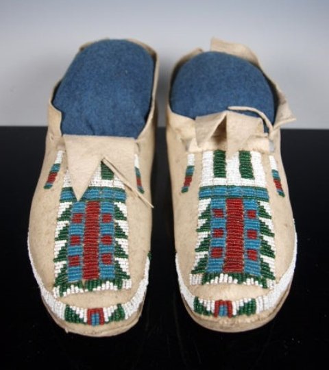 Early Native American Beaded Moccasins, Arapaho: Striking old pair of Arapaho moccasins, showing a pattern popular among many Plains tribes. Partially beaded on native-tanned hide with translucent red, translucent green, blue and white seed beads. P
