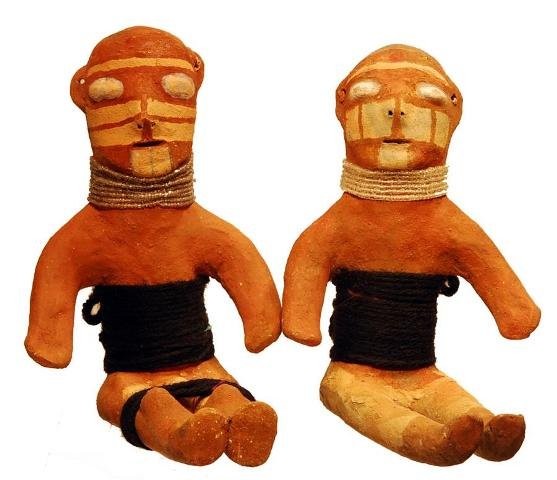 Mojave Indian Pottery Dolls by Annie Fields: Mojave Indian Pottery Dolls by Annie Fields Ca. Mid 20th Century. This fabulous pair of seated figurines, made of clay, has painted surfaces and face striping. They each wear rows of white cut-glass b