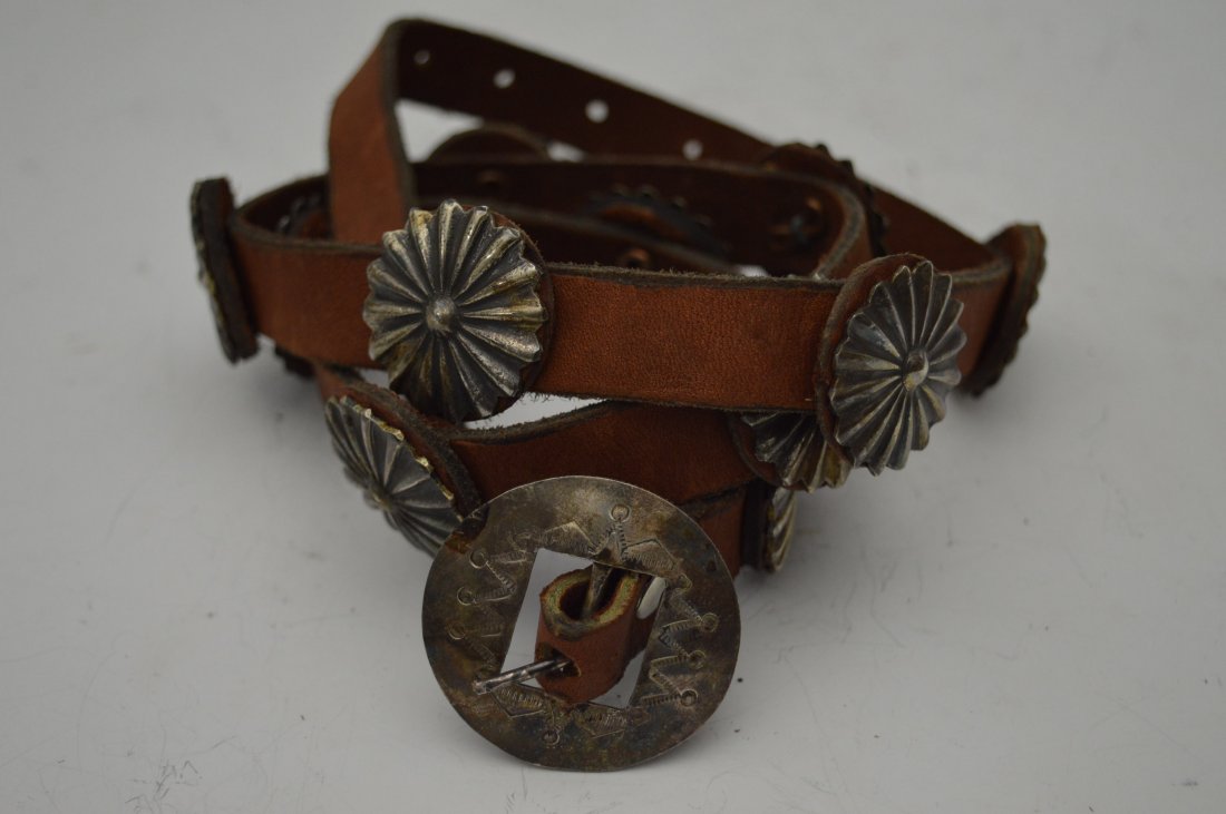 Navajo Silver Concho Belt: Navajo Silver Concho Belt, composed of 11 hammered conchos plus stamped buckle. FROM THE ESTATE OF JOHN KOEHLER. Mr. Koehler, an avid collector, had, at one time, purchased a defunct "Indian Trading P