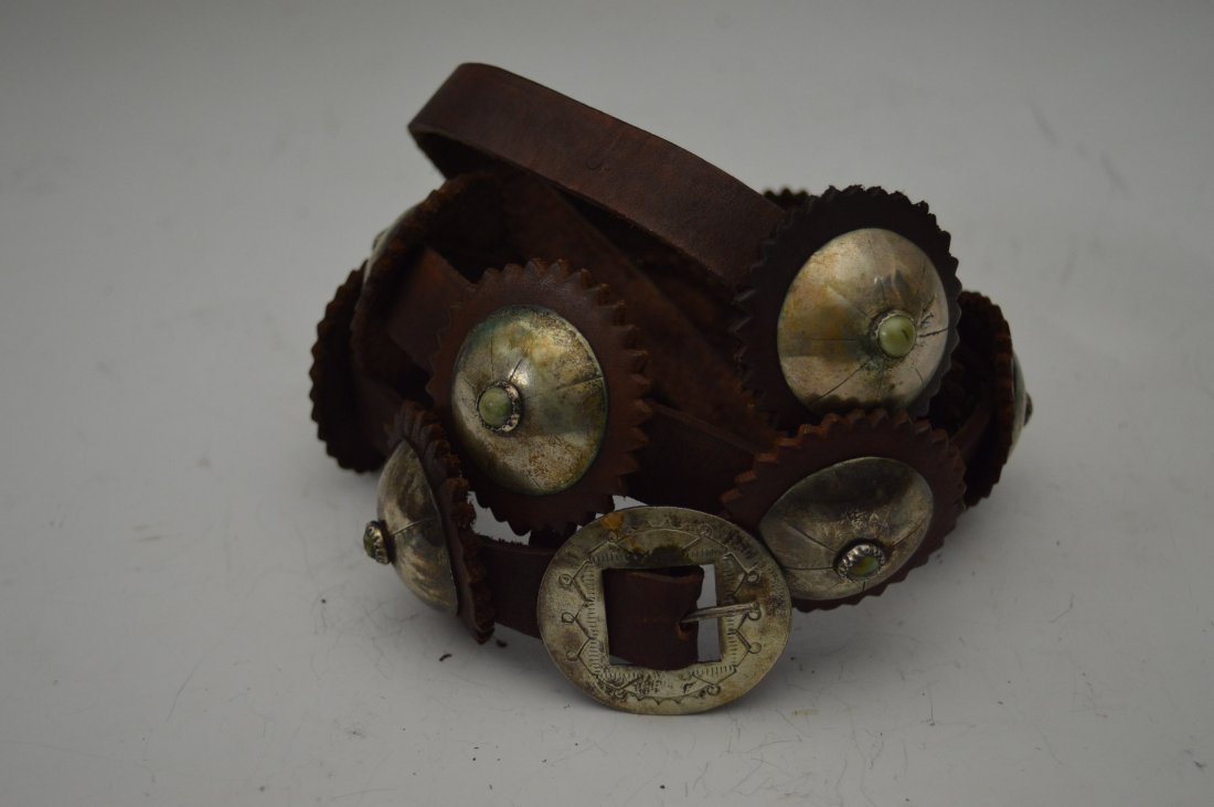 Navajo Silver Concho Belt: Navajo Silver Concho Belt, composed of 11 stamped conchos with turquoise sets in serrate bezels, plus stamped buckle. FROM THE ESTATE OF JOHN KOEHLER. Mr. Koehler, an avid collector, had, at one time,
