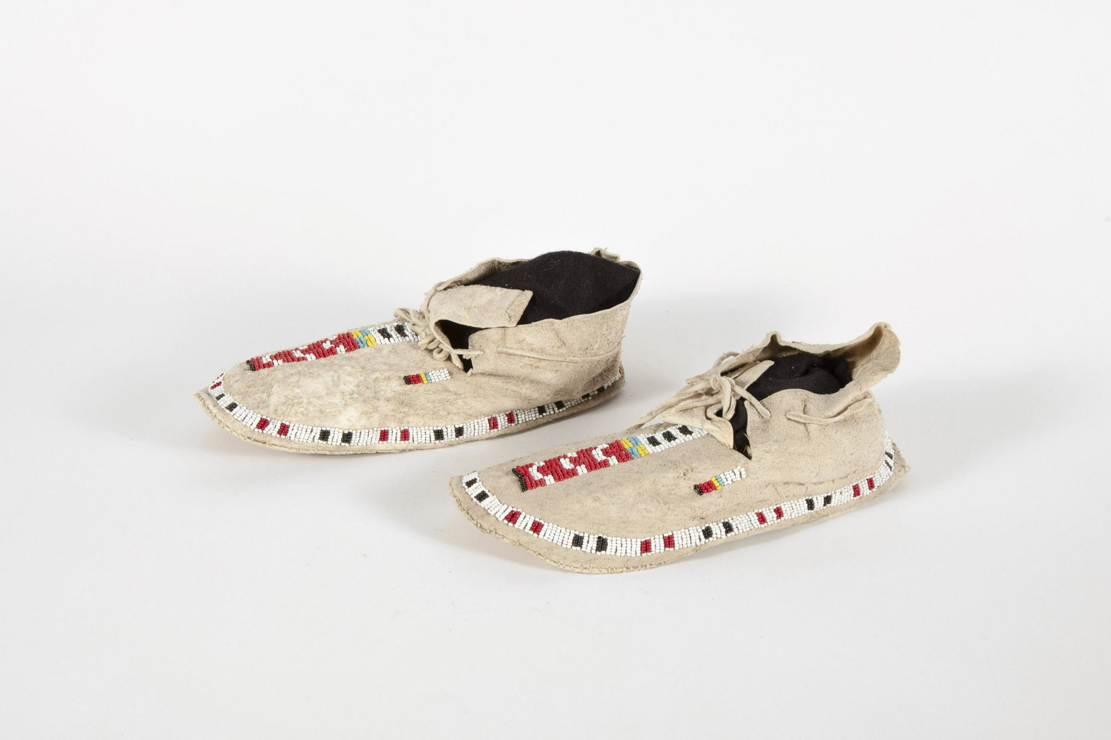 Apache, Pair of Adult Moccasins, ca. 1920: Apache Pair of Adult Moccasins, ca. 1920 Pair of Adult Moccasins, ca. 1920 hide, glass beads, thread length 10 1/2 x width 3 3/4 x height 3 1/2 in Provenance: Private Collection, Illinois
