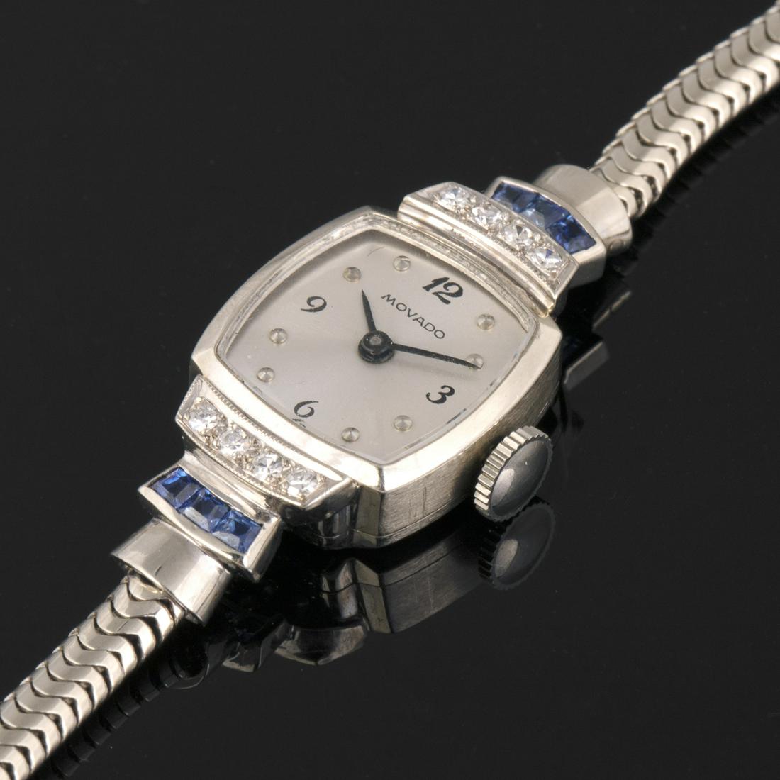 Movado Ref. 4045 White Gold, Diamond and Sapphire: Movado A White Gold, Diamond and Sapphire Bracelet WatchRef. 4045, Circa 1945Case: 14k white gold, snap on back, bezel set with diamonds and sapphires, No. 69922Dial: Silvered, applied dot indexesMove