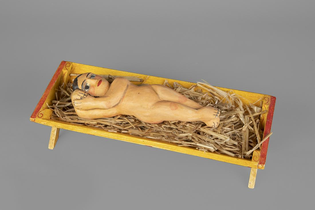 Marie Romero Cash, Christ in the Manger, 1983: Marie Romero Cash (b. 1942) Christ in the Manger, 1983 hand-adzed wood, gesso, pigments, straw, colcha-stitched cloth inscribed underside of manger: MARIE / ROMERO / CASH / 1983 11 5/8 x 5 x 4 3/4 in.