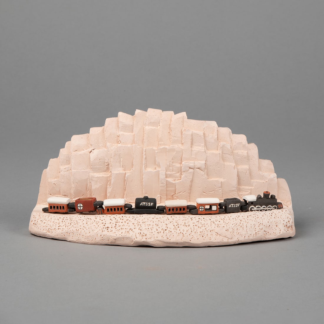 Thomas Natseway, Miniature Train Set with Stand: Thomas Natseway(Laguna, b.1953)Miniature Train Set with Standfired clay, pigmentsfeaturing seven cars plus engineStand: 3 1/2 x 8 x 3 in. (8.9 x 20.3 x 7.6 cm.)Train Car: .375 x 11 x 1 in. (1.9 x 27.9