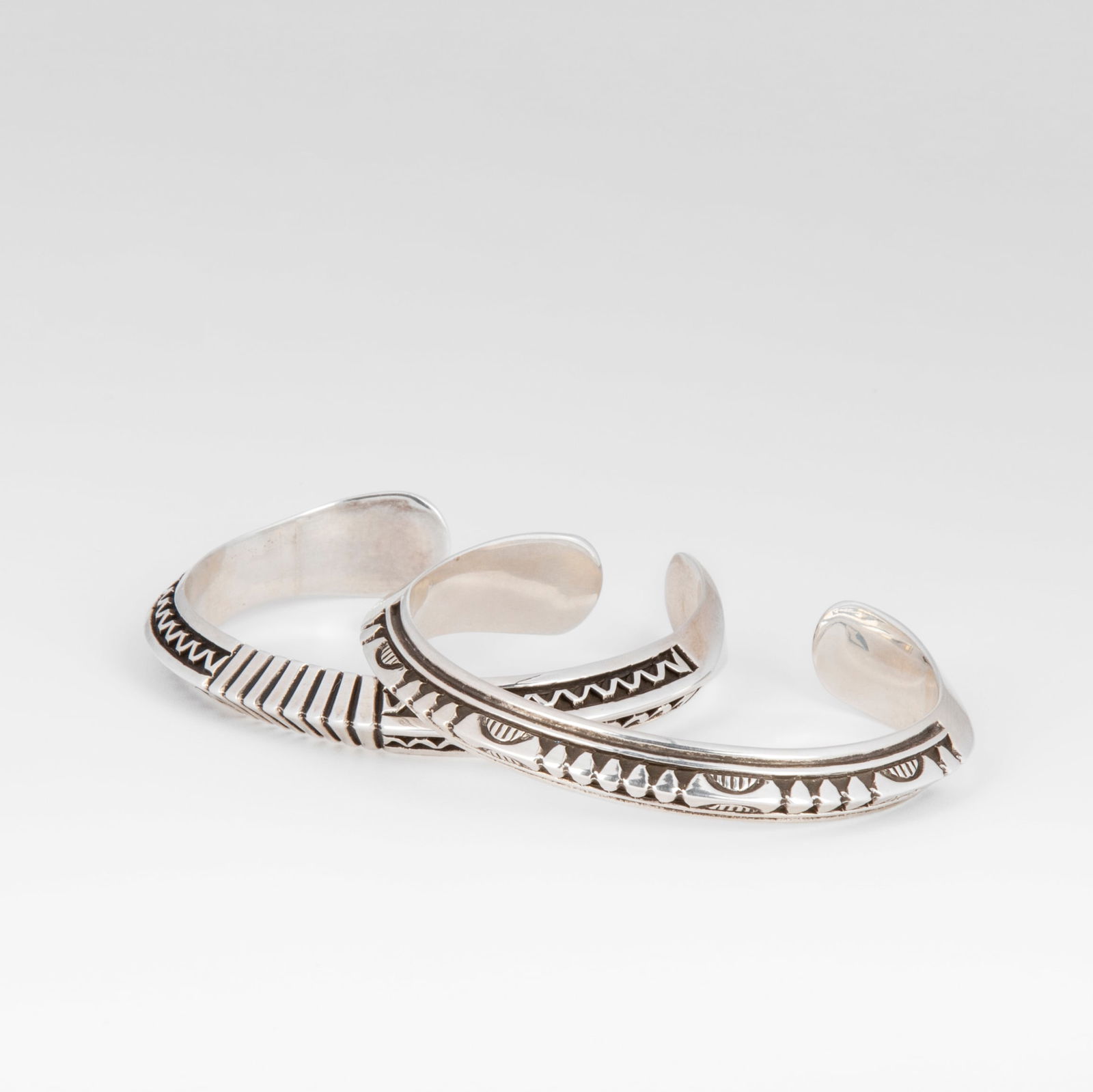 Lyle Secatero, Dine [Navajo], Pair of Silver Cuffs; Feather Fan Cuff ca. 2020 + Mountain Rain Silver (1 of 3)
