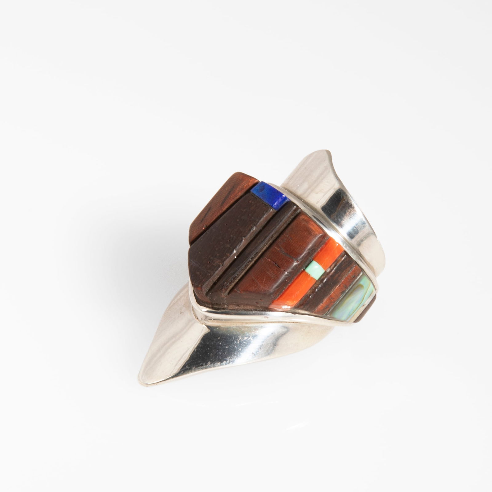 Sterling Silver and Multi-Stone Inlay Ring: Charles Loloma(Hopi, 1921 - 1991)Sterling Silver and Multi-Stone Inlay Ringsterling silver, iron wood, coral, fossilized bone, lapis, turquoise, abalonestamped verso: lolomaring size: 7, height: 1 3/4