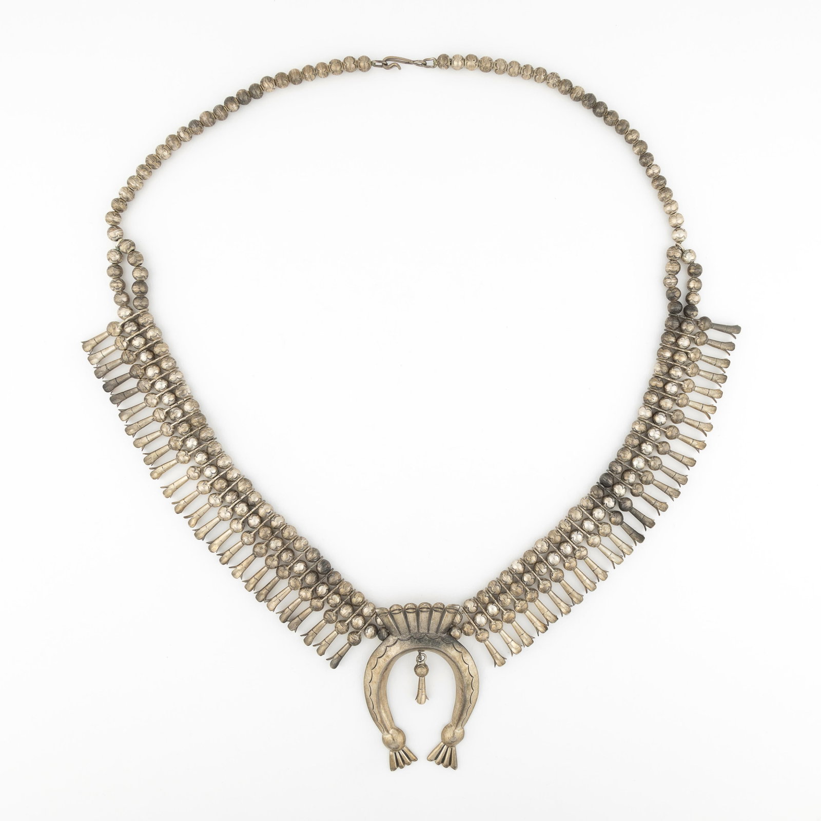Leonard Benally, Classic Sterling Squash Blossom Necklace: Leonard Benally DinÃ© [Navajo] Classic Sterling Squash Blossom Necklace sterling silver stamped: LB naja: 2 3/4 x 1 7/8 in. (7 x 4.8 cm.), hanging length: 15 3/4 in. (40 cm.) Private Collect