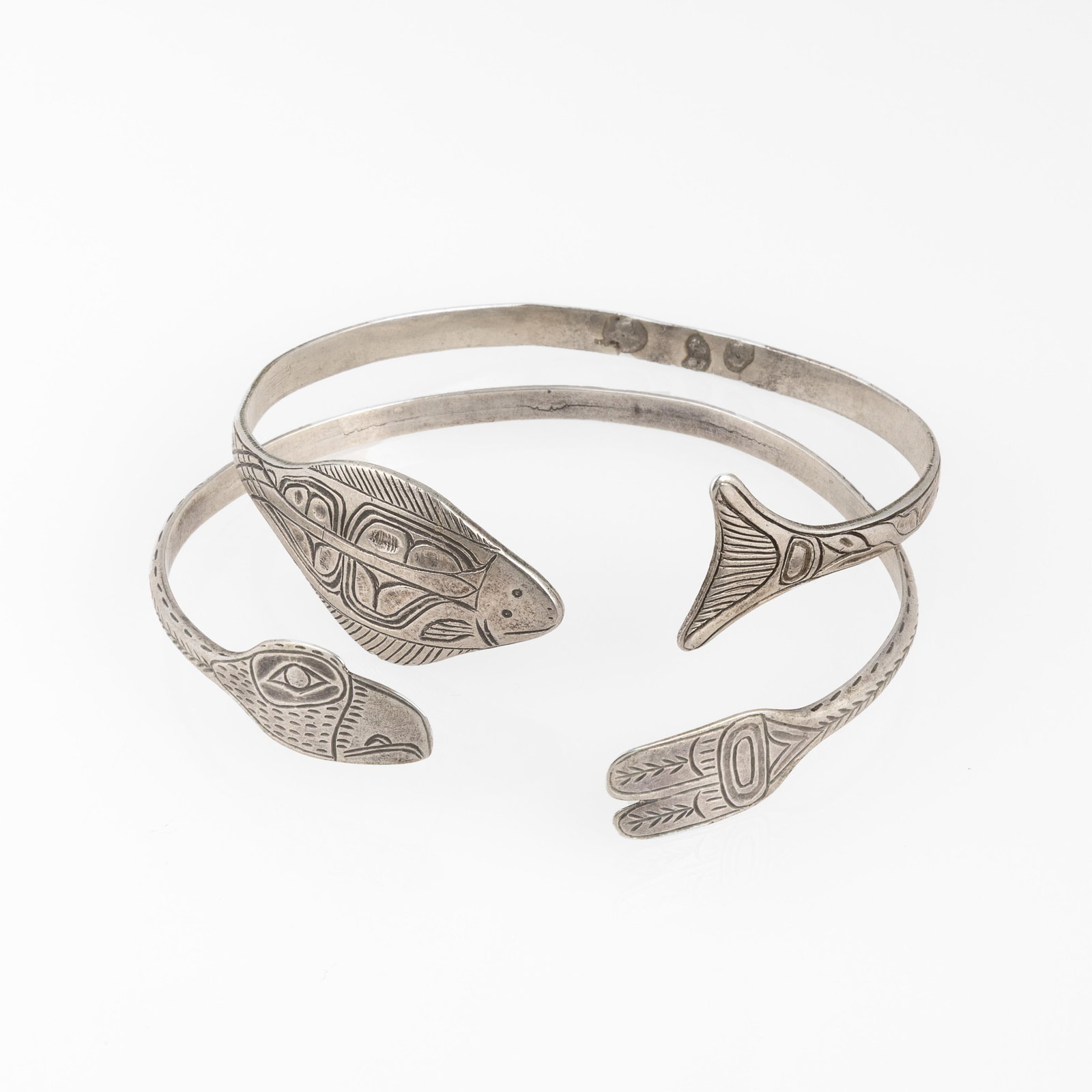 Northwest Coast, Pair of Silver Cuffs with Raven + Halibut Designs, ca. 1985: Northwest CoastPair of Silver Cuffs with Raven + Halibut Designs, ca. 1985silverRaven Cuffinner circumference: 7 1/4 in. (18.4 cm.), gap: 3/4 in. (1.9 cm.), width: 1/8 in. (0.3 cm.)Halibut Cuffinner c