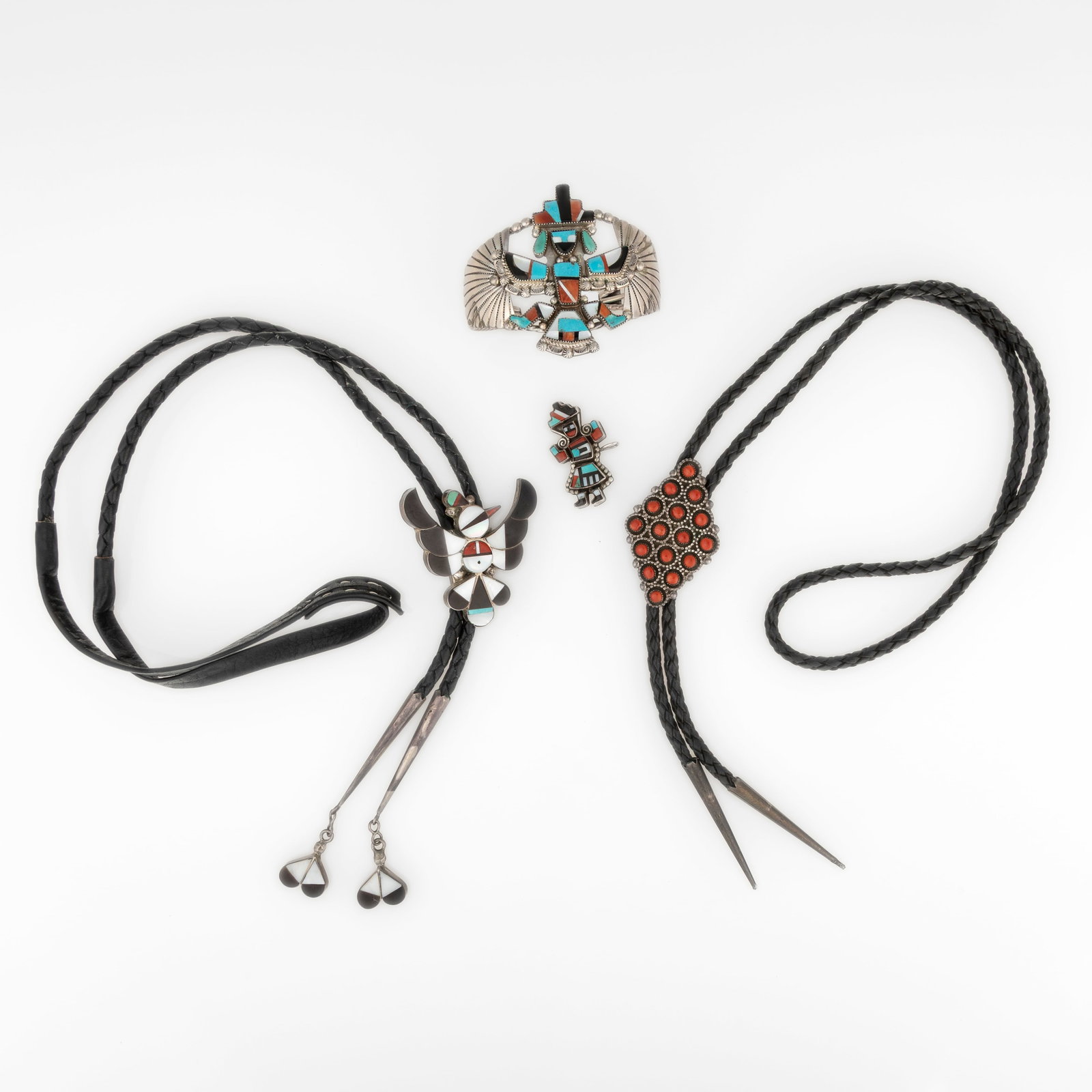 Leonard Matza et al, Group of Four Jewelry Works: Cuff + Two Bolos + Pin/Pendant: Leonard Matza et al Zuni, 20th Century Group of Four Jewelry Works: Cuff + Two Bolos + Pin/Pendant sterling silver, jet, turquoise, coral, mother of pearl Leonard Martza Zuni, b. 1928- Large Sterling 