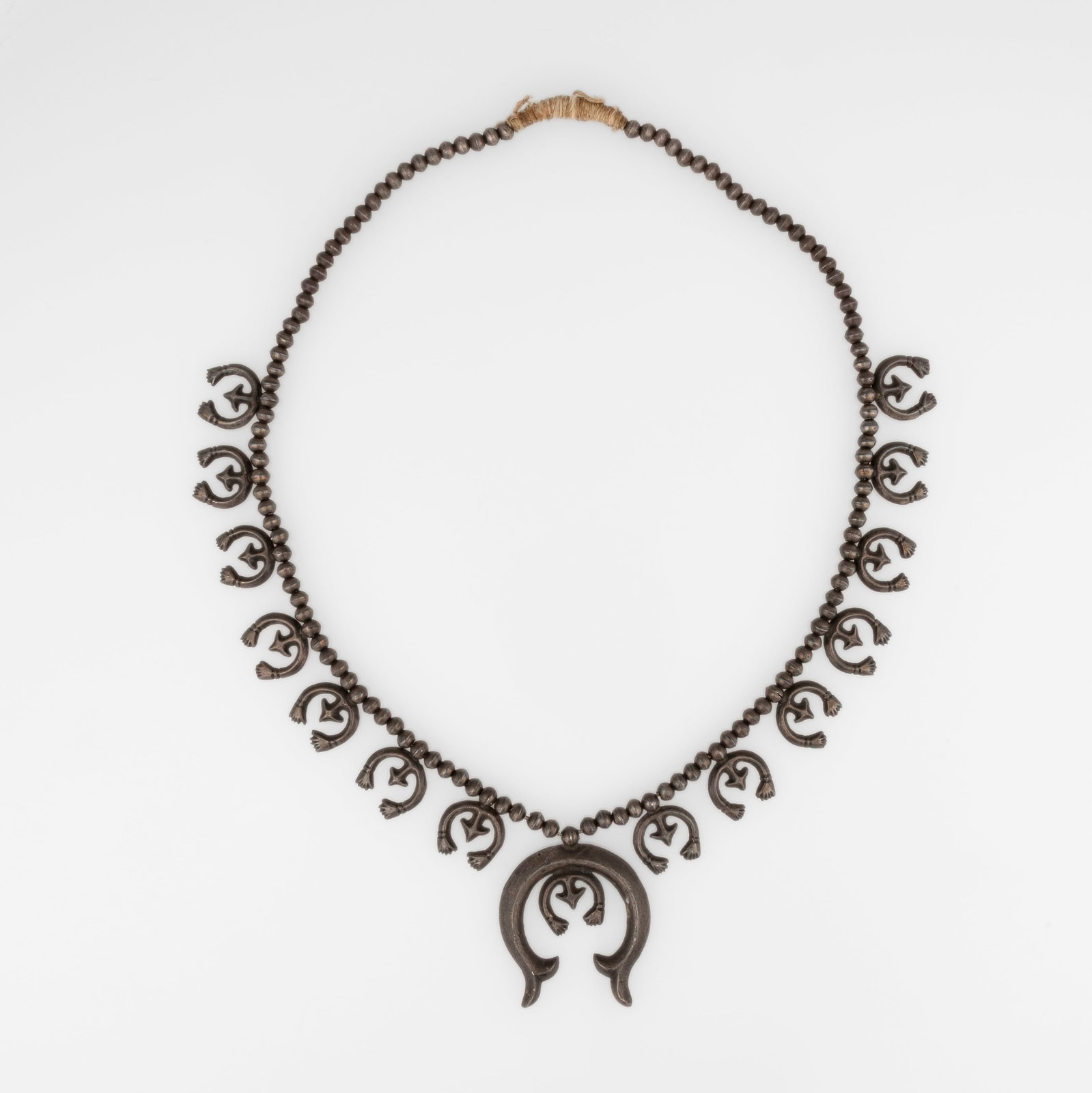 Diné (Navajo), Silver Squash Blossom Necklace, ca. 1955: Diné (Navajo) Silver Squash Blossom Necklace, ca. 1955 silver gross weight: 91 g. hanging length: 14 5/8 in. (37.1 cm.), naja: 2 x 1 7/8 in. (5.1 x 4.8 cm.) Private Collection, New Mexico