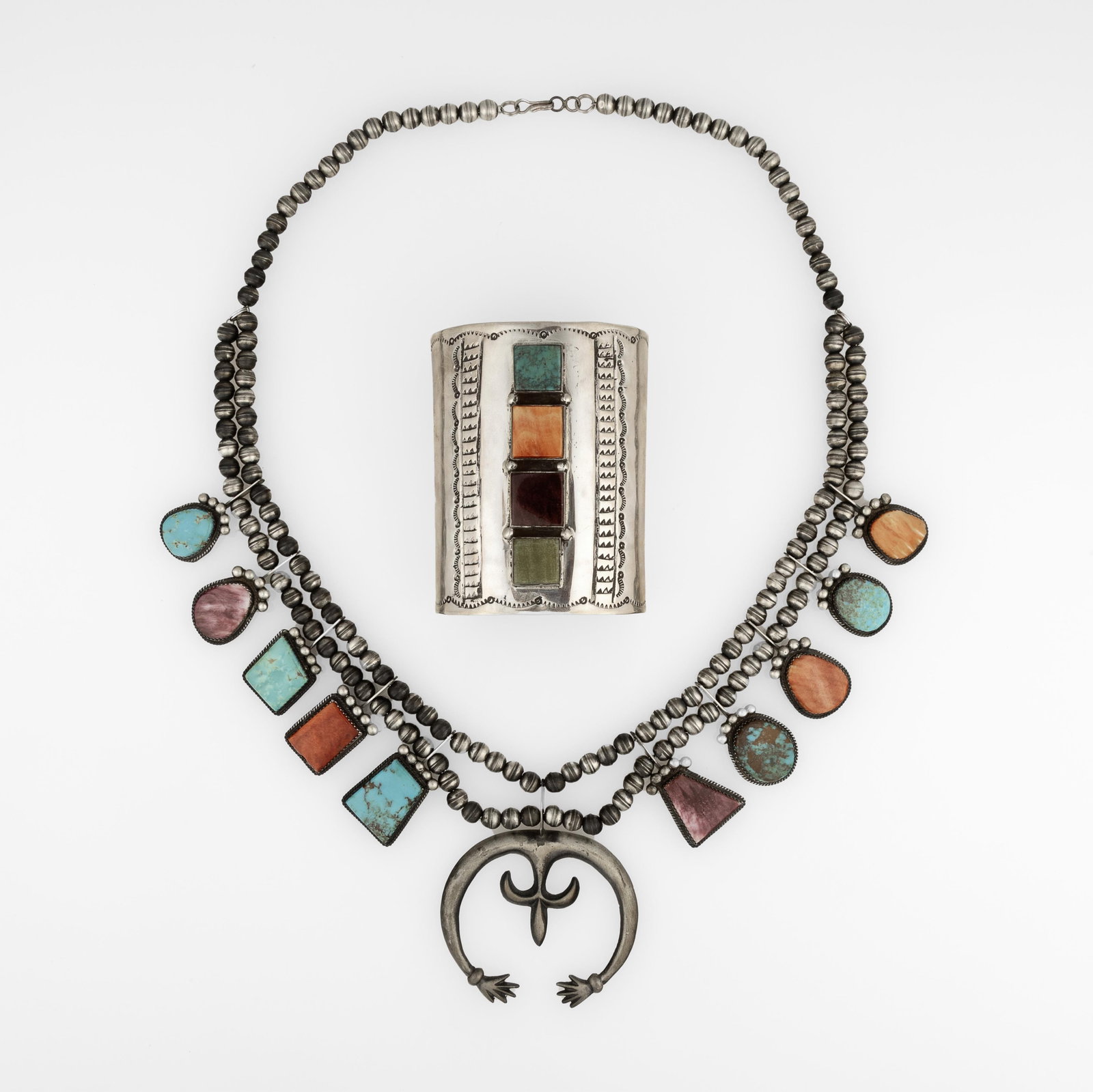 Diné (Navajo) + Kewa (Santo Domingo), Two Mixed Stone Jewelry Works: Squash Blossom Necklace +: Diné (Navajo) + Kewa (Santo Domingo) Two Mixed Stone Jewelry Works: Squash Blossom Necklace + Cuff, ca. 2000 spiny oyster, turquoise, sterling silver Diné (Navajo) Squash Blossom Necklace stamped: G