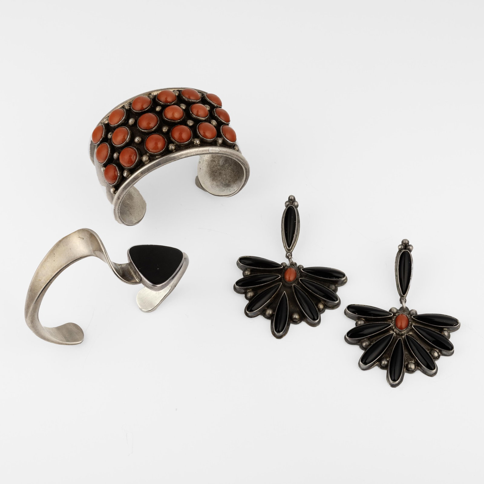 attributed Diné (Navajo), Set of Three Jet and Coral Jewelry Items: Two Cuffs + Pair of Earrings,: attributed Diné (Navajo) Set of Three Jet and Coral Jewelry Items: Two Cuffs + Pair of Earrings, ca. 2010 coral, jet, silver Coral Cuff inner circumference: 5 1/4 in. (13.3 cm.), gap: 1 in. (2.5